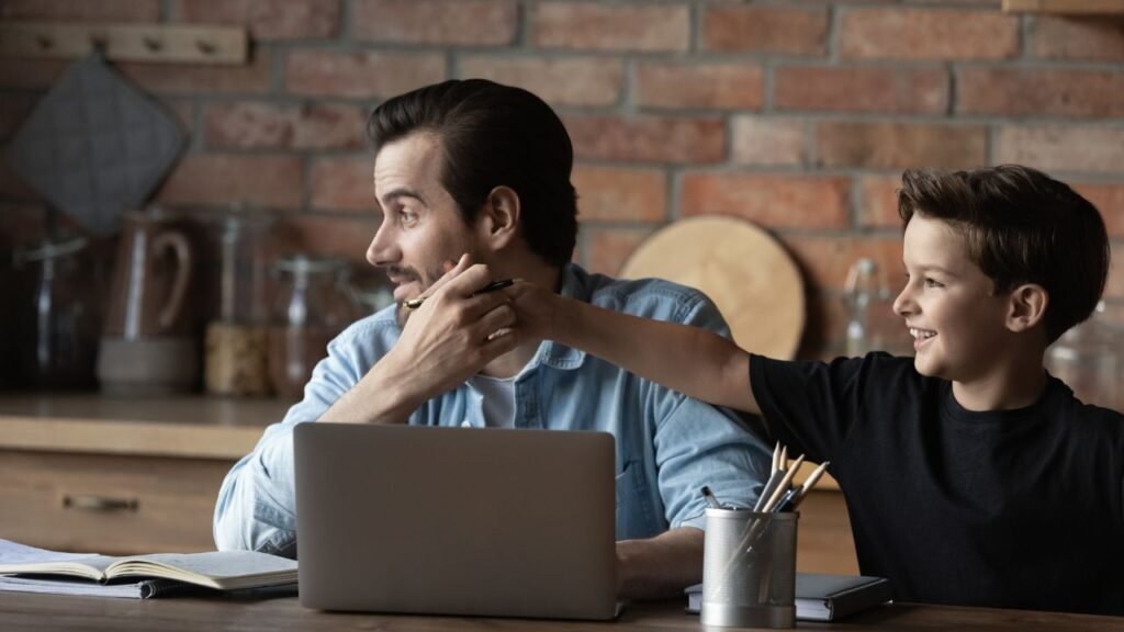 A teen distracting his dad when working at home