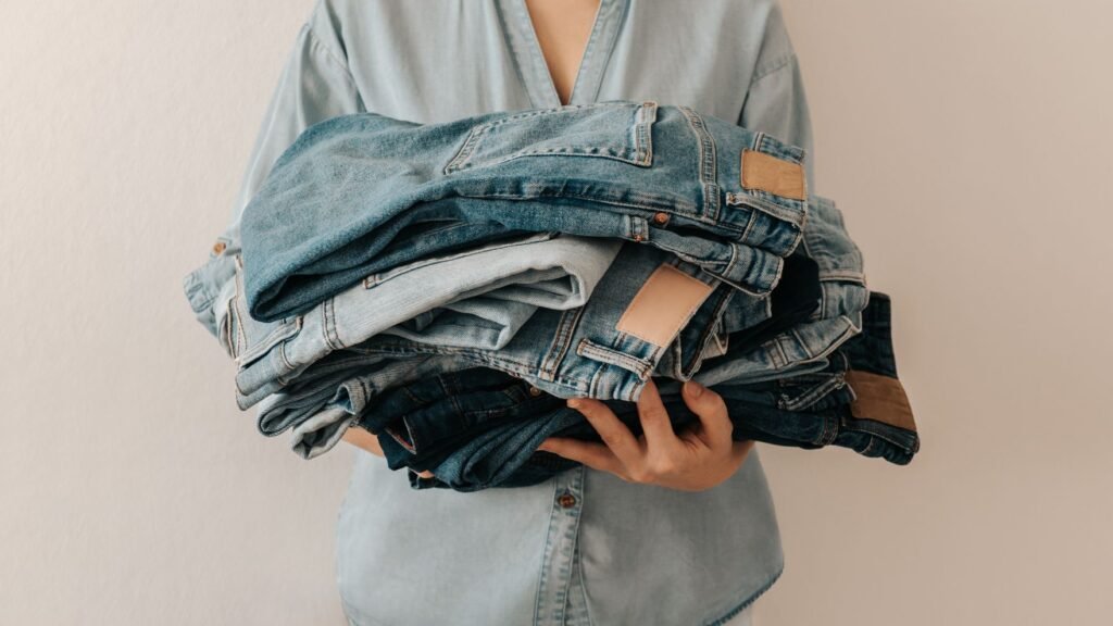 Woman holding a stack of jeans